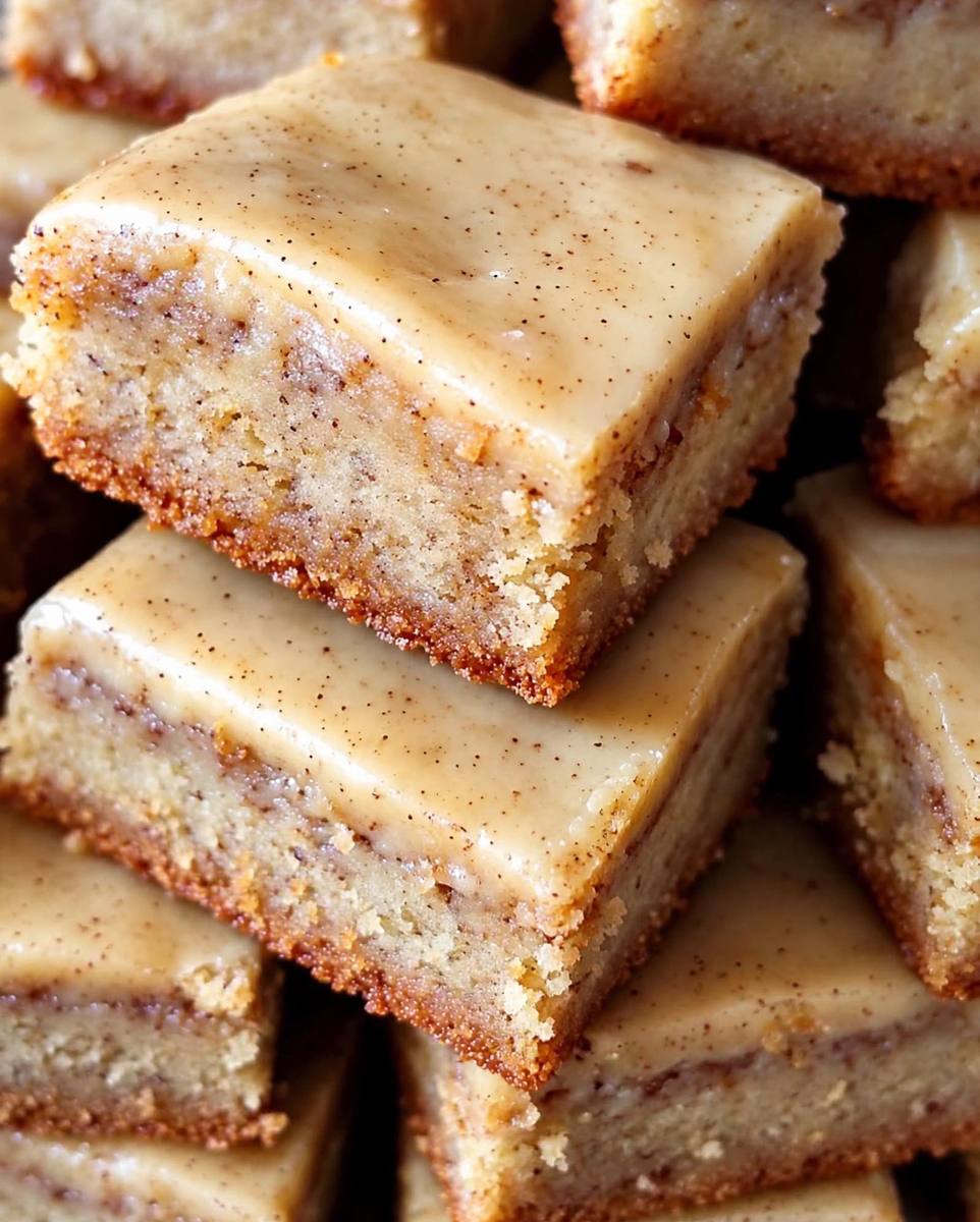 Soft banana bread brownies with brown butter cinnamon frosting stacked in squares